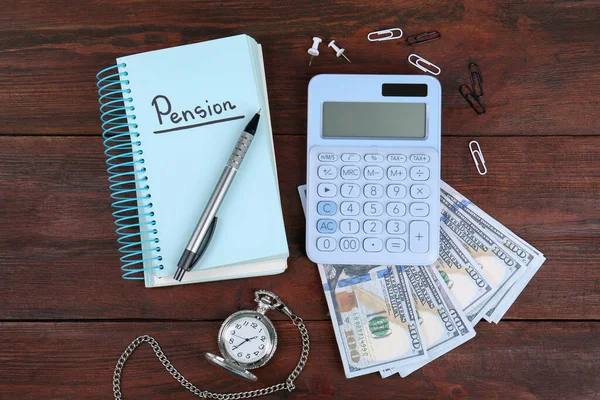 Calculator, notebook with word Pension, pen, dollar banknotes, paper clips and watch on wooden table, flat lay. Retirement concept