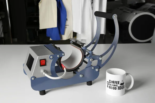 Printing logo. Heat press and cup on white table