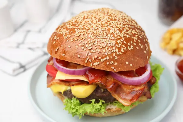 Delicious burger with bacon, patty and vegetables on white table, closeup