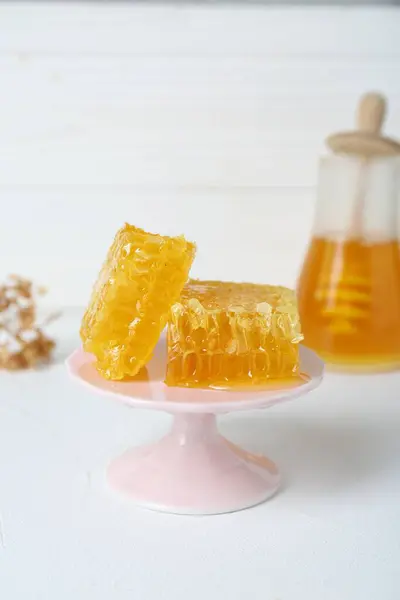 ホワイトテーブルに天然のハニカムと蜂蜜で立って 選択的な焦点 テキスト用スペース ストック画像