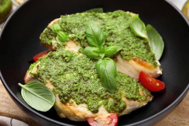 Pesto soslu leziz tavuk göğsü, domates ve fesleğen, yakın plan.