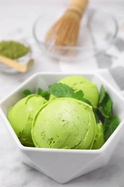 Tasty matcha ice cream in bowl on white table, closeup
