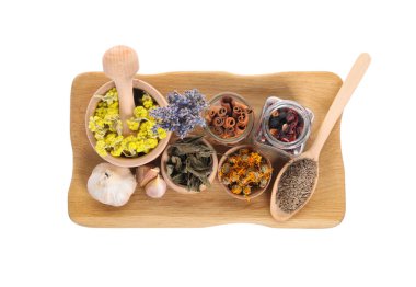 Kabuklu havan, beyaza izole edilmiş birçok farklı kuru ot ve baharat.