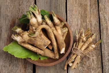 Taze yaban turpu kökleri ve yaprakları ahşap masada, düz yatıyordu.