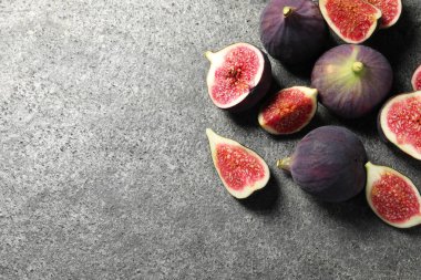 Gri desenli sehpada tam ve olgun incirleri düz bir şekilde kes. Metin için boşluk