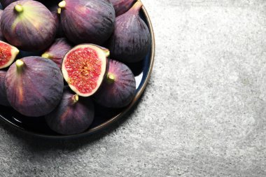 Açık gri desenli masa, üst manzara, bütün ve olgun incir kesimi. Metin için boşluk