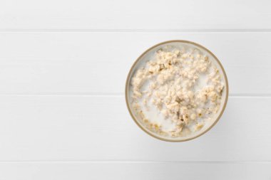 Beyaz ahşap masada, tabakta kaynamış yulaf ezmesi, üst manzara. Metin için boşluk