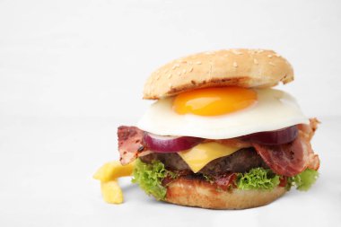 Beyaz fayanslı masada kızarmış yumurtalı leziz burger, yakın plan. Metin için boşluk
