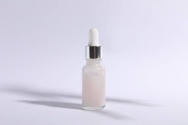 Bottle of cosmetic serum on white background