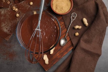 Bir kase çikolatalı krema, çırpı ve kaşık masada, düz yatıyordu.