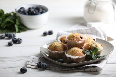 Yaban mersinli leziz tatlı kekler ve beyaz ahşap masada nane şekeri. Metin için boşluk