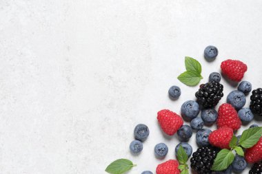 Beyaz desenli masa üzerinde bir sürü taze olgun böğürtlen, düz. Metin için boşluk