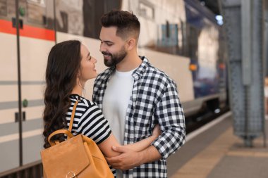 Uzun mesafeli ilişki. Tren istasyonu platformunda güzel bir çift