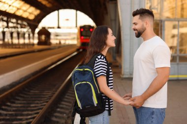 Uzun mesafeli ilişki. Tren istasyonu platformunda güzel bir çift, mesaj için yer