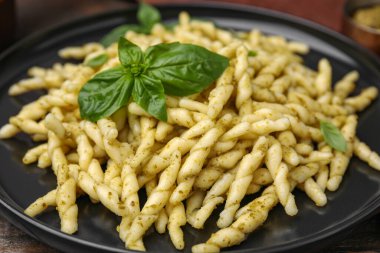 Pesto soslu ve fesleğen yapraklı lezzetli trofie makarna tabağı, yakın plan.