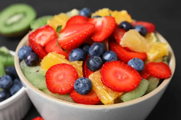 Salată Delicioasă Fructe Proaspete Bol Ingrediente Masa Întunecată Closeup — Fotografie, imagine de stoc