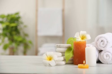 Beyaz mermer masa içerisindeki farklı spa ürünleri ve plumeria çiçekleriyle kompozisyon, metin için boşluk