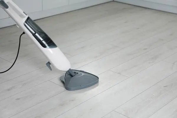 Cleaning floor with steam mop at home. Space for text