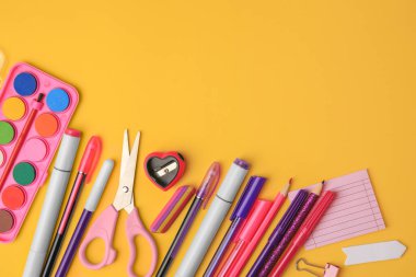 Turuncu arka planda farklı okul kırtasiyesine sahip düz kompozisyon, metin için boşluk. Okula geri dön.