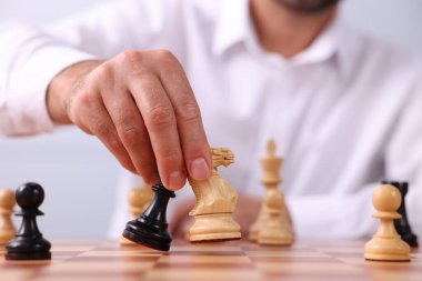 Satranç taşlarını dama tahtasında hareket ettiren adam, yakın plan