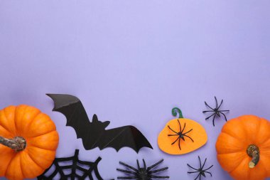 Mor arka planda yarasa, balkabağı ve örümceklerle düz kompozisyon, metin için boşluk. Cadılar Bayramı