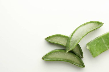 Beyaz arka planda taze aloe vera parçaları, düz. Metin için boşluk