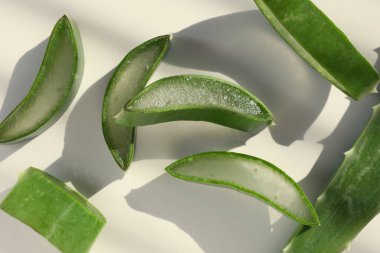 Taze aloe vera parçaları beyaz masada, düz yatıyordu.