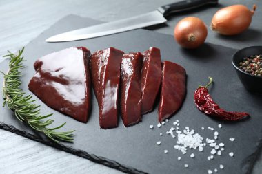 Biberiye, baharat ve bıçakla kesilmiş çiğ sığır ciğeri, yakın plan.