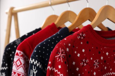 Açık arkaplanda farklı Noel süveterleriyle dizilin, yakın plan