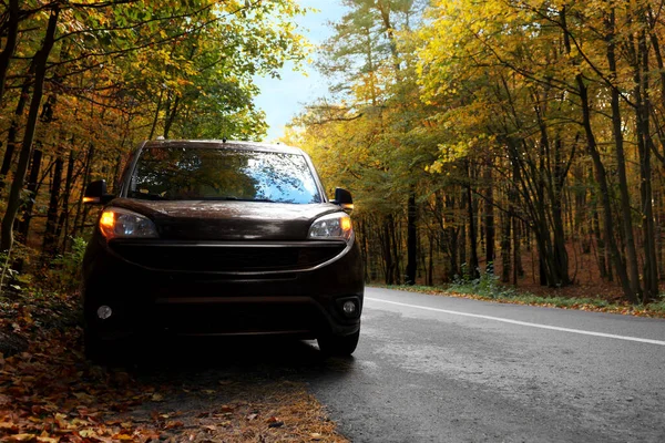 stock image Modern car on asphalt road near autumn forest