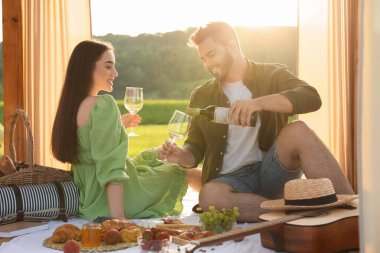 Romantik bir randevu. Güneşli bir günde dışarıda piknik yapan güzel bir çift.