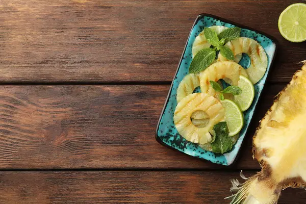 Lezzetli ızgara ananas dilimleri, nane ve ahşap masada limon dilimleri, düz yatak. Metin için boşluk