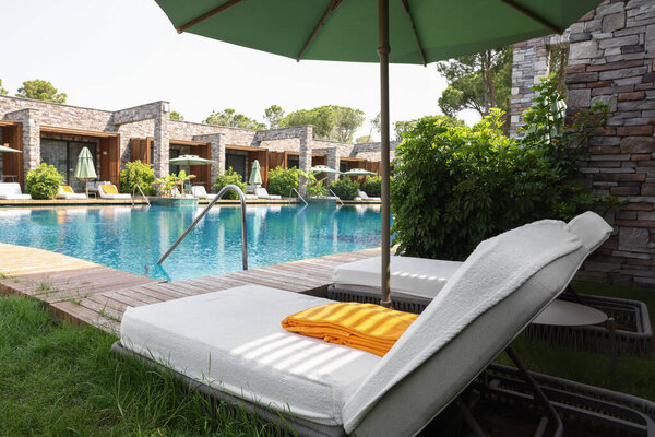 Sunbeds near outdoor swimming pool at luxury resort