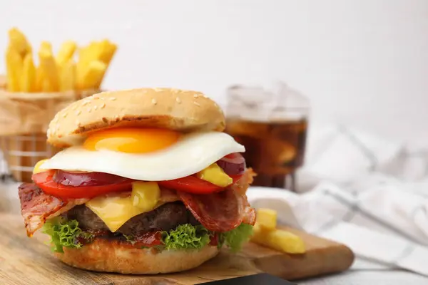 Delicious burger with fried egg on table, closeup. Space for text