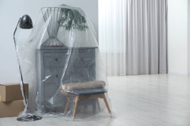 Modern mobilya, plastik film ve kutularla kaplı ev bitkisi. Metin için boşluk