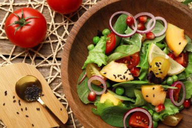 Tahta masada servis edilen şeftalili, yeşil bezelyeli ve sebzeli nefis salata.