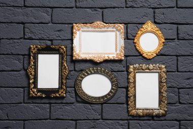 Siyah tuğla duvarda asılı boş vintage çerçeveler. Tasarım için model