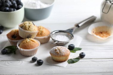 Şeker, yaban mersini ve beyaz ahşap masada naneli tatlı çörekler.