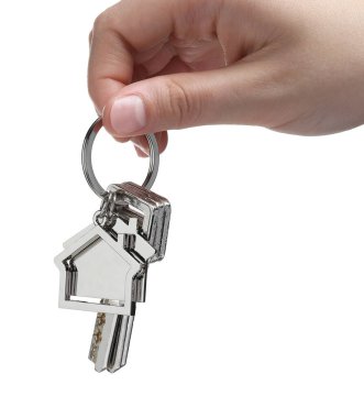 Anahtarlığı ev şeklinde olan bir kadın beyaz üzerine izole edilmiş, yakın plan.