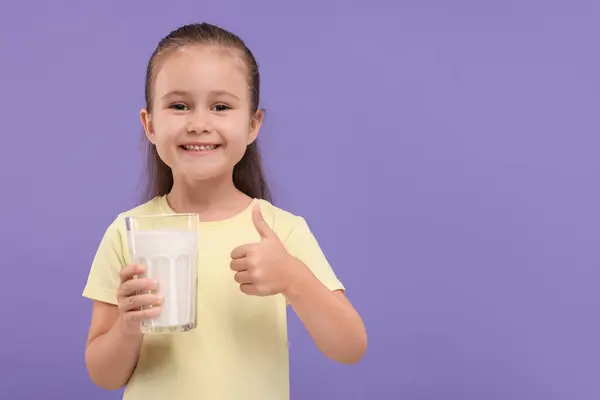 Мила Дівчина Склянкою Свіжого Молока Показує Великий Палець Фіолетовому Фоні — стокове фото