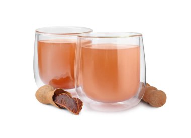 Bir bardak demirhindi suyu ve beyaz üzerine izole edilmiş taze meyveler.