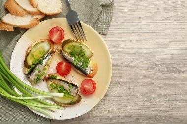 Lezzetli sandviçler, salatalık turşusu ve ahşap masada domatesle servis edilen yeşil soğan. Metin için boşluk