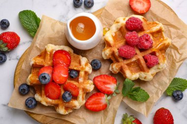 Lezzetli Belçika waffleları. Taze böğürtlenler ve beyaz mermer masa üzerinde bal.