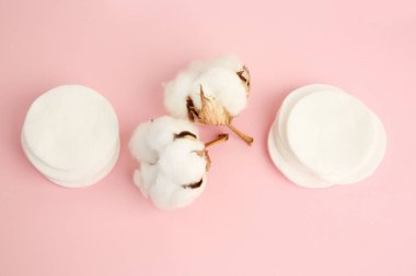 Pembe arka planda pamuk pedler ve çiçekler.