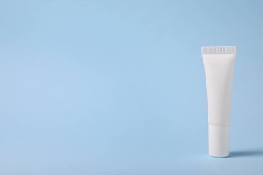 Açık mavi arkaplanda bir dudak kremi, metin için boşluk