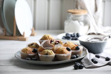 Beyaz ahşap masada yaban mersinli lezzetli çörekler.
