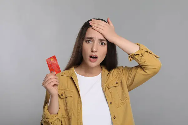 Zaszokowana Kobieta Kartą Kredytową Szarym Tle Problem Zadłużenia — Zdjęcie stockowe