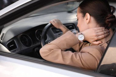 Arabasında boynu ağrıyan genç bir kadın.