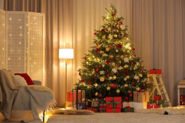 Oturma odasındaki Noel ağacının altında güzel paketlenmiş hediyeler. Şenlikli iç tasarım