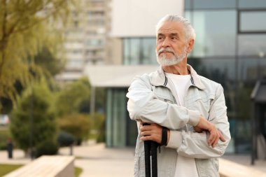 İskandinav yürüyüş direkleri olan kıdemli bir adam açık havada, metin için yer var.